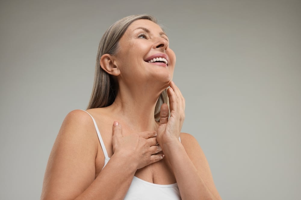 Beautiful,Woman,With,Healthy,Skin,On,Grey,Background,,Low,Angle