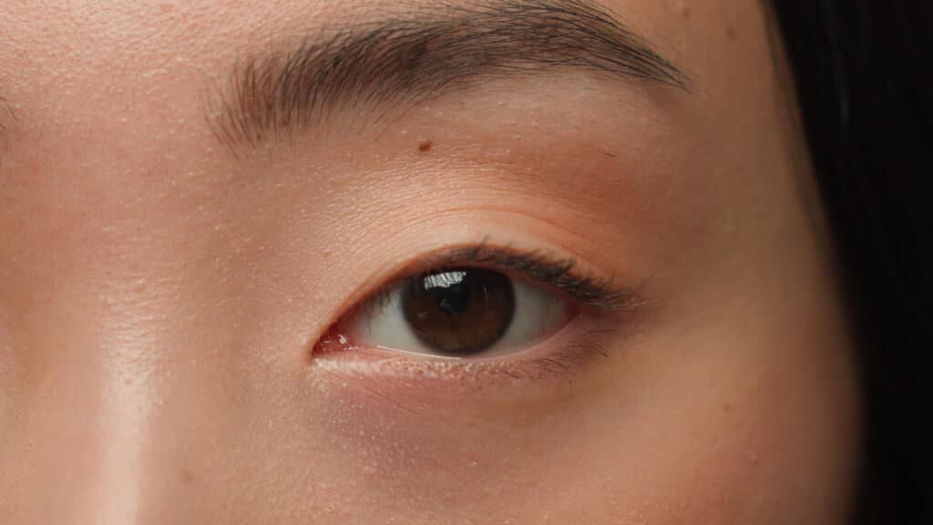 Extreme close up female dark eyes details Asian woman girl korean chinese ethnic healthy japanese lady eyesight human eye opening iris eyeball blink eyelash gaze vision beauty face skincare cosmetics. High quality 4k footage